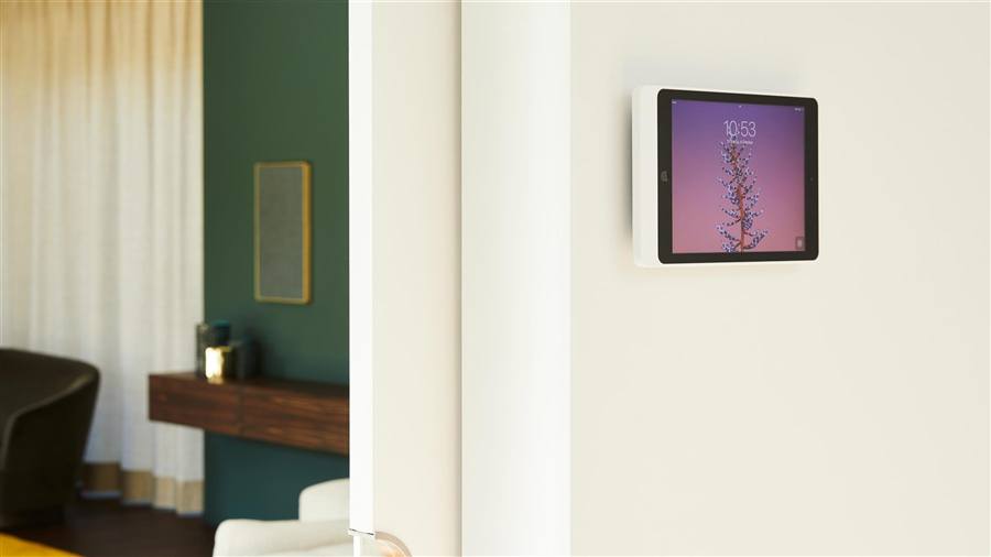 حامل Eve مع iPad غاطس بمستوى الجدار، وخلفه غرفة خضراء بسماعة Plano جدارية